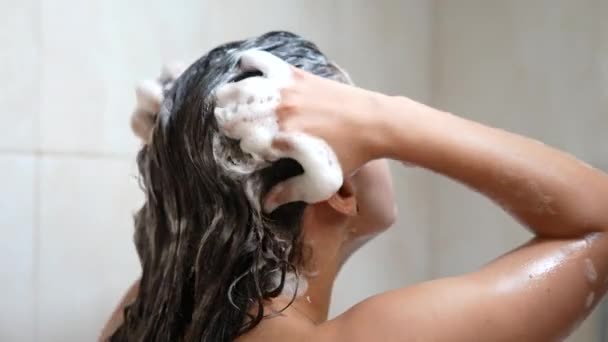 Μια γυναίκα κάνει ντους και λούζεται τα μαλλιά της στο μπάνιο. - Πλάνα, βίντεο