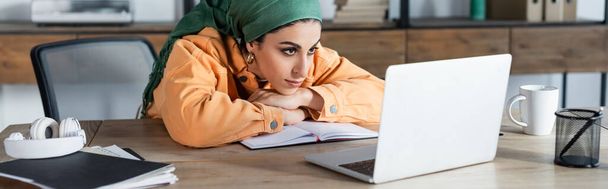 Araberin konzentriert sich auf Online-Webinar, während sie zu Hause lernt, Banner - Foto, Bild