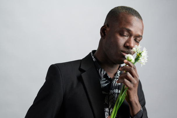 African man enjoying the beautiful flower - Fotoğraf, Görsel