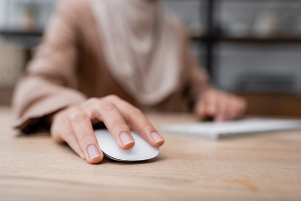selective focus of computer mouse in hand of cropped woman working on blurred background - Foto, Imagem