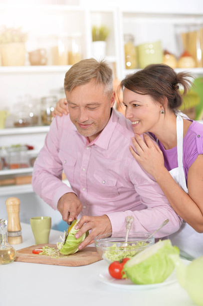 Couple doing salad in the kitchen at home - Фото, изображение