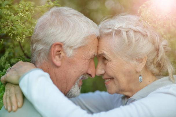 Happy senior couple posing in summer park - Фото, изображение