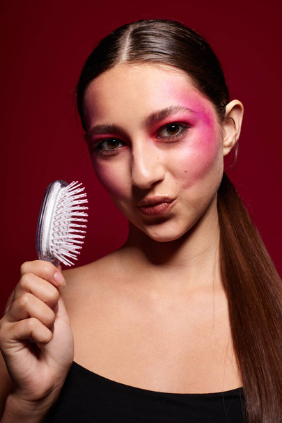 όμορφη γυναίκα με μια χτένα στο χέρι φωτεινό μακιγιάζ ποζάρουν τα συναισθήματα μόδας μοντέλο στούντιο - Φωτογραφία, εικόνα