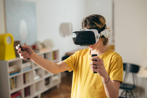 teenage boy using VR headset for entertaining - Foto, Imagem