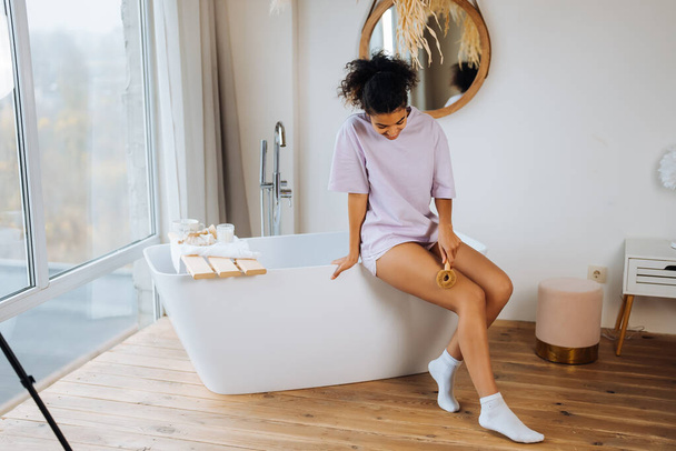 Mujer afroamericana cuida su piel en el baño - Foto, imagen