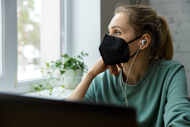 беспокоилась, что депрессивная женщина носит маску на работе и смотрит в окно. концепция психического здоровья и выгорания - Фото, изображение