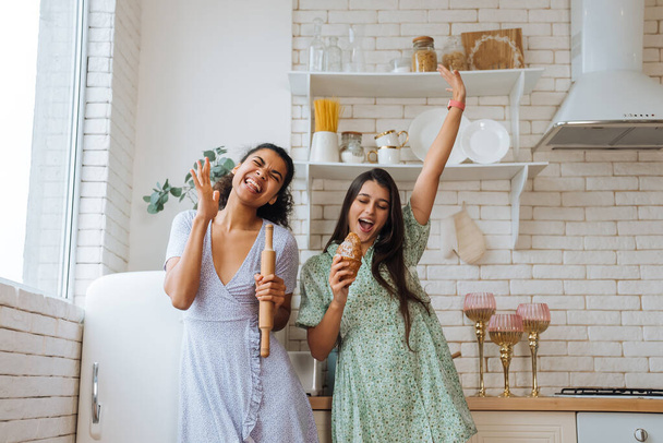 zwei Mädchen unterschiedlicher Rassen haben Spaß in der Küche - Foto, Bild