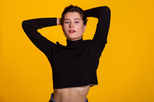 Woman with short hair being very glad smiling with broad smile having fun indoors. Joyful and excited femlae face expression isolated over yellow background with space for text. - Zdjęcie, obraz