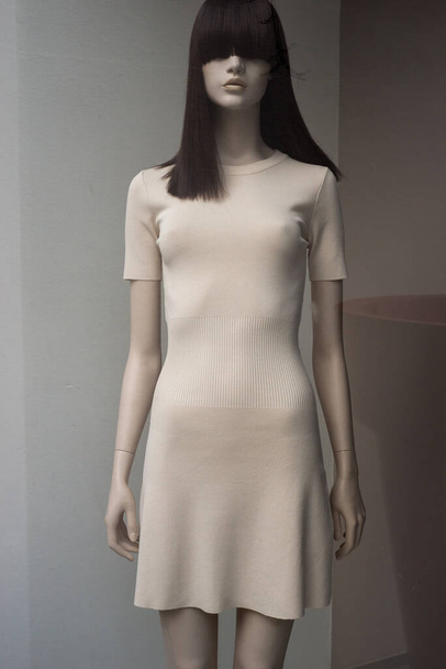 Closeup of beige dress on mannequin in a fashion store showroom - Fotoğraf, Görsel