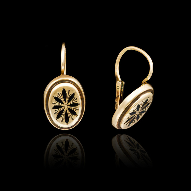 Gold earrings isolated on black background  - Photo, Image