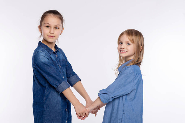 Two happy friends or sisters kid girls hugging. Together having fun and posing emotional on white background, happy smiling, friendship and relationship lifestyle people concept - Fotografie, Obrázek