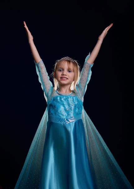 Młoda śnieżna księżniczka. Tajemnica fantasy dziewczyna w niebieski bujny strój na czarnym tle w studio - Zdjęcie, obraz