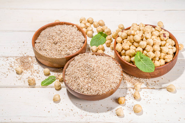 Alternative keto diet gluten grain free flour. Paleo and ketogenic diet baking cooking concept. Hazelnut flour with whole nuts - Foto, Imagen