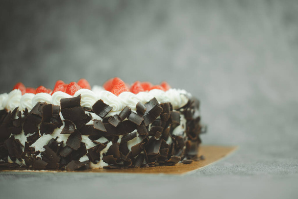 Vanilla cake decorated with fresh fruits and chocolate. Delicious and sweet strawberry cake for Valentine or birthday party. Homemade bakery concept - 写真・画像