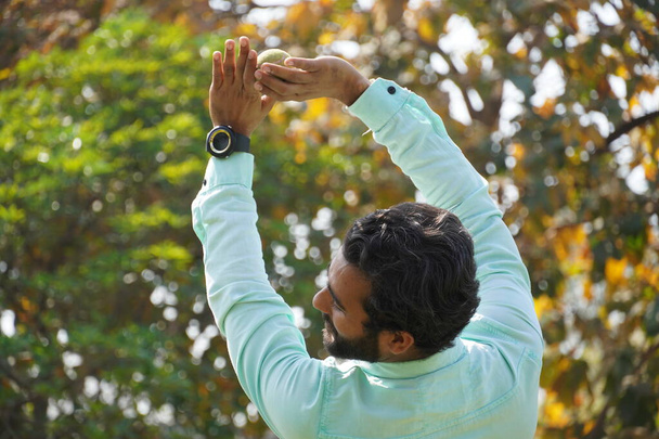 Індійський чоловік ловить м'яч у матчі з крикетом. - Фото, зображення