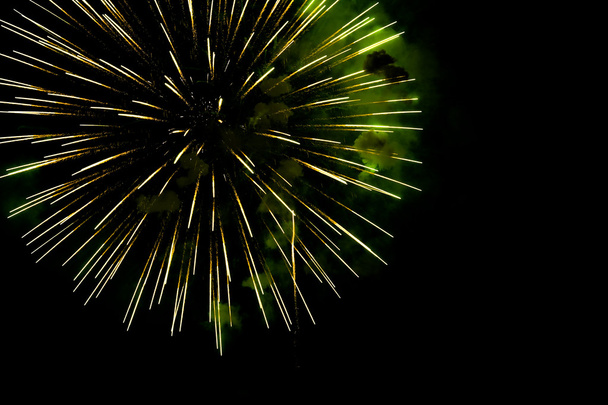 A burst of golden- green fireworks against a night sky. - Photo, Image