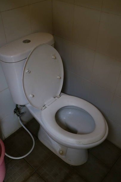 white ceramic toilet in the corner of the bathroom photo - Photo, Image