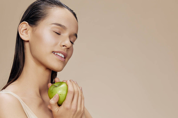 schöne Frau grüner Apfel nahe Gesicht Gesundheit isoliert Hintergrund - Foto, Bild