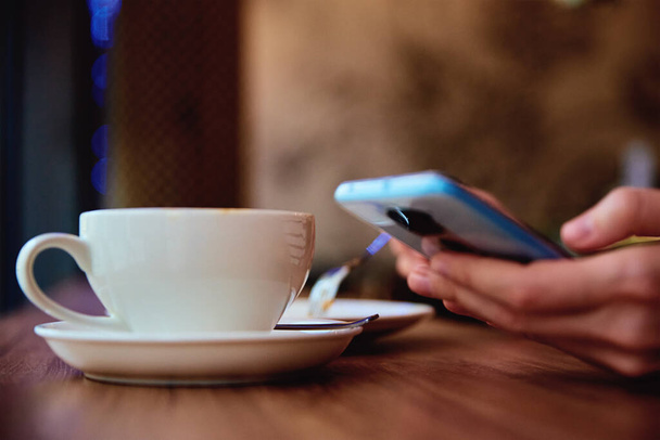 Vrouw ontbijten in café, smartphone gebruiken in café - Foto, afbeelding