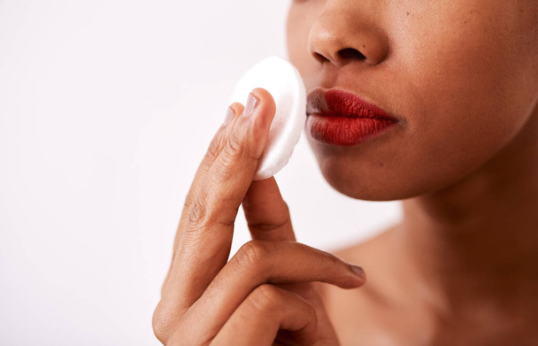 A cotton pad is gentle on your skin. Studio shot of an unrecognizable woman using a cotton pad to remove her lipstick. - Foto, Imagem