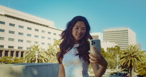 Hübsche Frau macht Selfie in Nahaufnahme. Asiatisches Mädchen fotografiert sich im Sommer selbst. - Foto, Bild