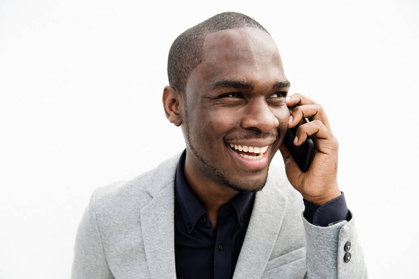 Ritratto ravvicinato di uomo d'affari afroamericano che ride con il cellulare da sfondo bianco isolato - Foto, immagini