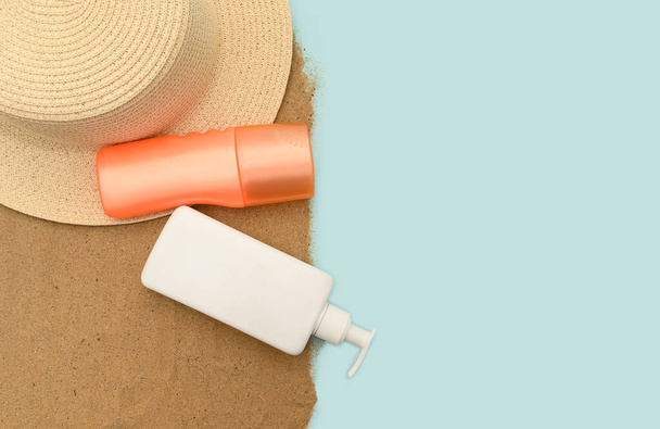 The concept of summer holidays at sea. Straw hat and protective cream in an orange plastic container. - Photo, Image