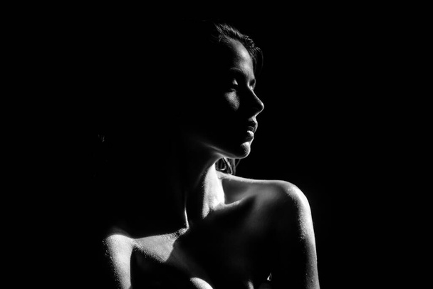 Tender girl, tenderness. Elegant young woman posing over black background. Light and shadow. Portrait of a beauty woman face. - Fotografie, Obrázek