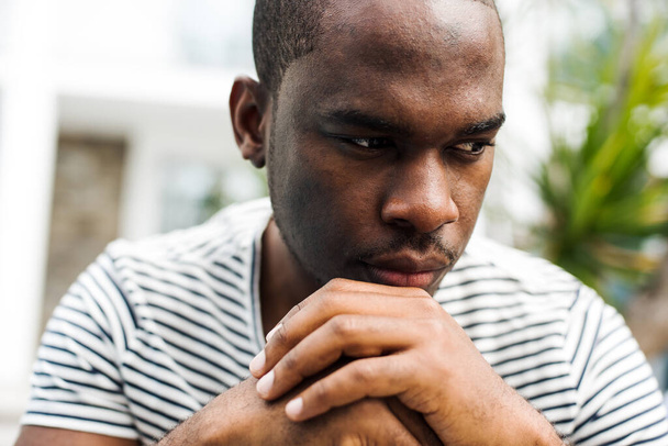 Close up retrato afro-americano homem sentado e olhando para longe em pensamento - Foto, Imagem