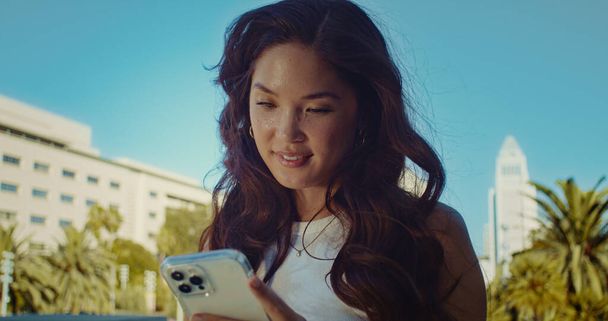 A boldog nő portréja okostelefon közeli képet használ. Ázsiai lány gépelés üzenet. - Fotó, kép
