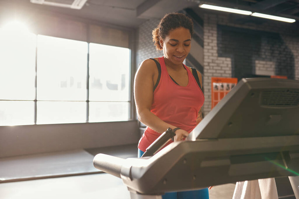 Black girl push button on treadmill while run - Zdjęcie, obraz