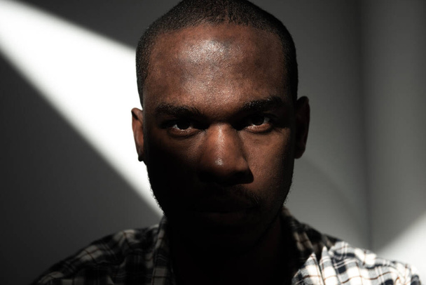 Close up portrait tough looking african american man in shadow - Foto, afbeelding