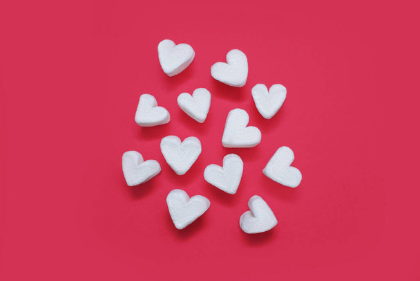 Białe pianki w kształcie serca na różowym tle. Koncepcja walentynek w postaci piankowych serc. Przewiewny słodki deser lub gorąca czekolada akompaniament - Zdjęcie, obraz