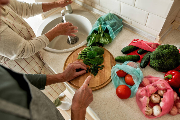 Cropped image of elderly couple cooking salad - Фото, изображение