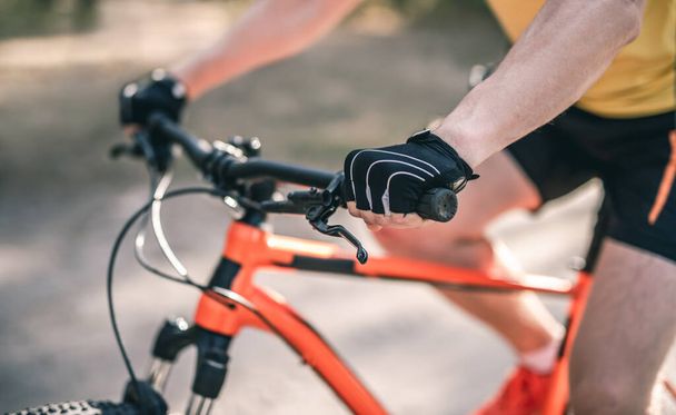 Hands in gloves on bike handlebar - Fotó, kép