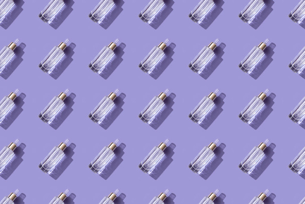 Pattern osmetic product, a beautiful bottle with a pipette on a trendy purple background, sunlight creates shadows and reflections. Demonstrating very peri, color of 2022 year. - 写真・画像