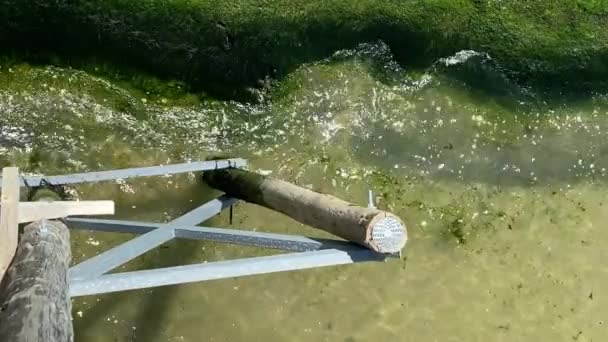 Golven van de zee crashen op het strand en rond oude metalen ligplaatsen aan de kust - Video