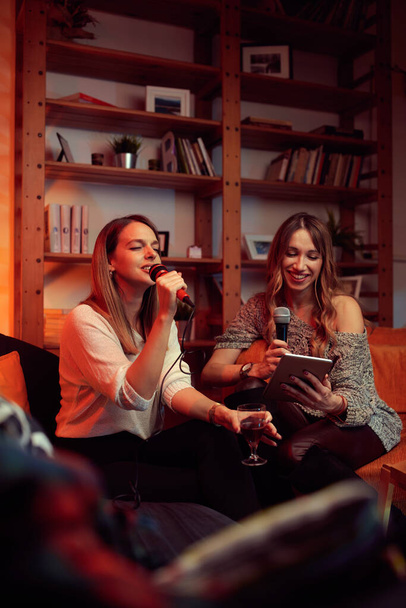 Güzel sesli yetenekli kızlar evde oturur ve karaoke gecesinde düet yaparlar.. - Fotoğraf, Görsel
