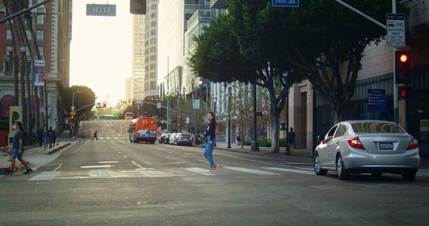 Young woman crossing street following traffic rules. Asian girl walking road - Photo, Image