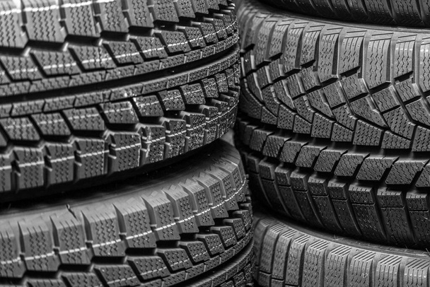 pisar fragmentos de vários pneus de inverno novos como um fundo escuro - Foto, Imagem