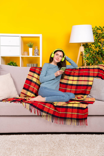 Full body vertical portrait of peaceful charming person sit sofa chill playlist isolated on yellow color background - Fotoğraf, Görsel