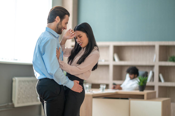 Man behaving improperly with his female colleague in the office - Фото, зображення