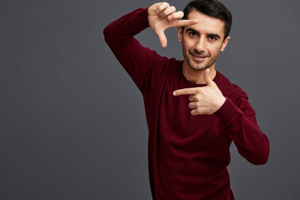 succesvolle man in een trui poseren emoties elegante stijl grijze achtergrond - Foto, afbeelding