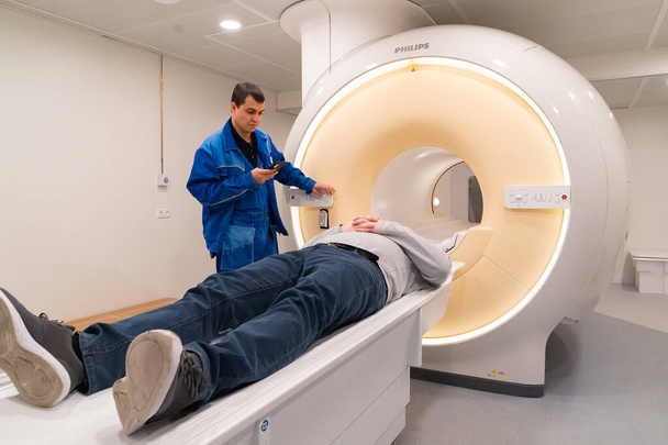 one engineer of mri apparatus lies in scanner and adjusts it, philips - Fotografie, Obrázek