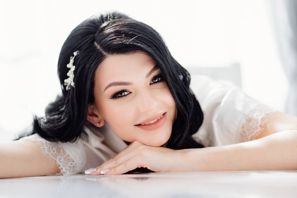 the face of a beautiful brunette bride with long hair and a white hairpin.  - Foto, Imagen