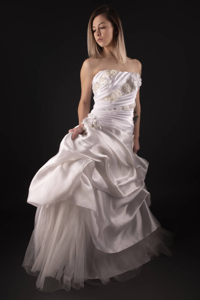 Sexy Braut zurück Brautkleid. Frau zieht weißes Kleid aus. Rückansicht Dame über schwarzem Hintergrund. Brautmode - Foto, Bild