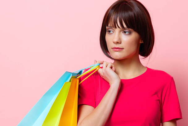woman with colorful shopping bags pink background - Foto, afbeelding