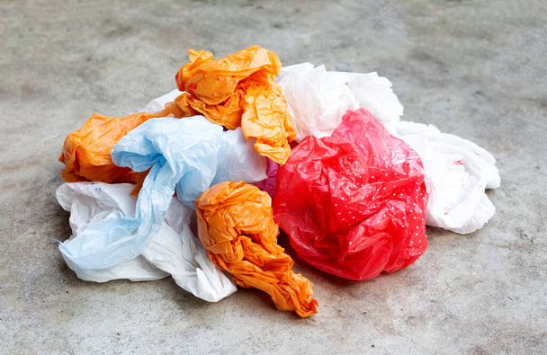 Барвисті пластикові пакети на цементній підлозі
 - Фото, зображення