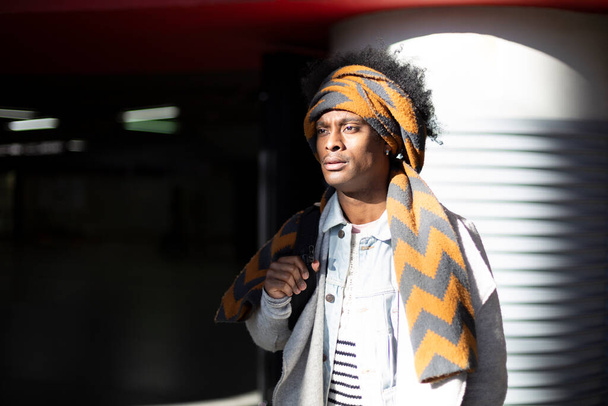 Молодий афроамериканець з головним шарфом чекає на станції метро. Простір для тексту. - Фото, зображення