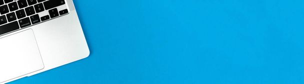 Ordinateur portable plat laïc fond de bannière bleue. Table de bureau, concept de design minimal. Vue du dessus, espace de copie - Photo, image